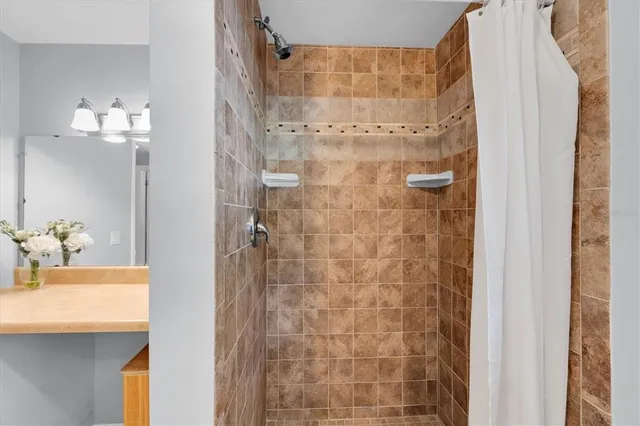 a bathroom with a sink shower and a mirror