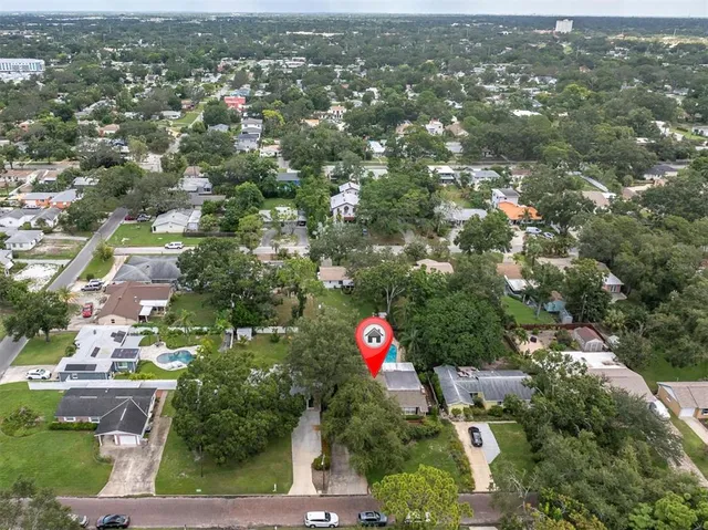 an aerial view of residential houses with city and outdoor space