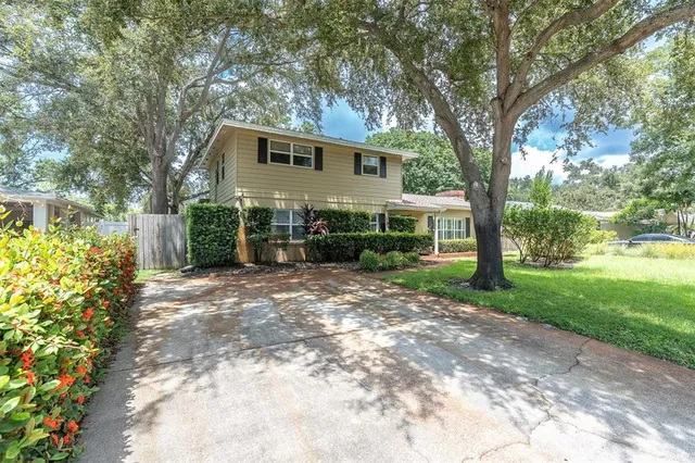 a view of a house with backyard and sitting area