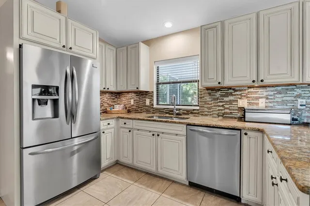 a kitchen with stainless steel appliances granite countertop a refrigerator sink and cabinets