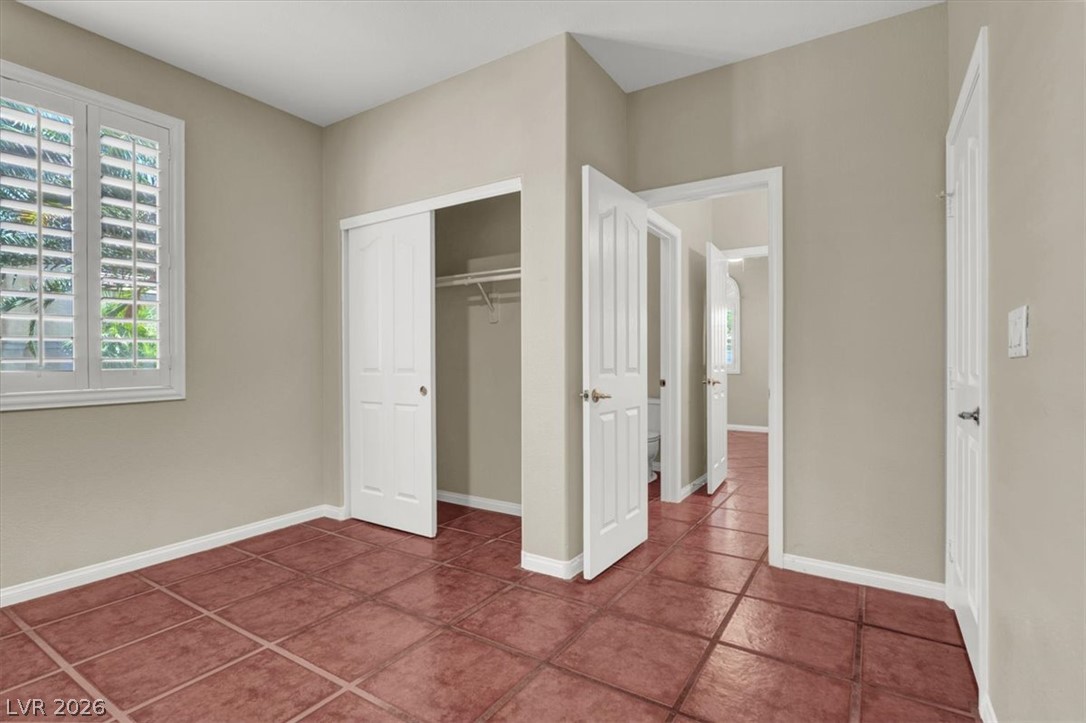 7308 Rustic Meadow Street Las Vegas, NV 89131 - Photo 15 of 27 A quiet secondary bedroom offering a closet and tiled flooring for easy maintenance.