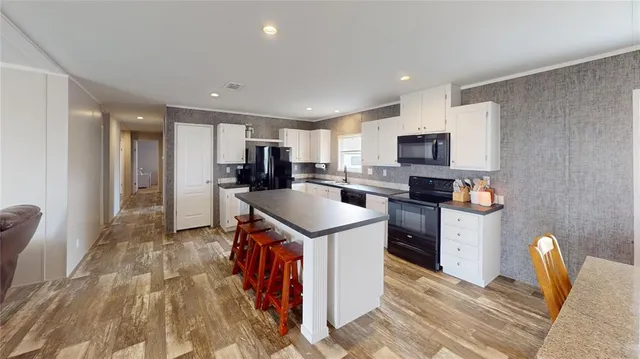 a kitchen with a sink a counter top space cabinets stainless steel appliances and a window