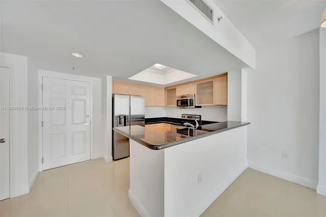 a kitchen with stainless steel appliances granite countertop a sink a stove and a refrigerator