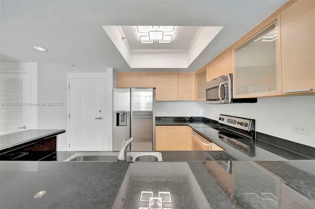 a kitchen with stainless steel appliances granite countertop a refrigerator and microwave