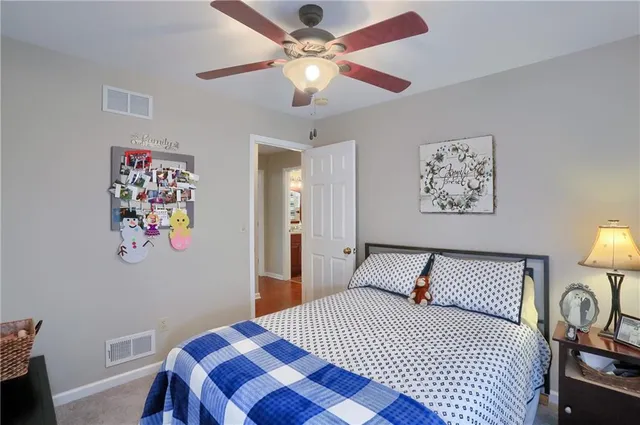 a bedroom with a bed and a lamp on dresser