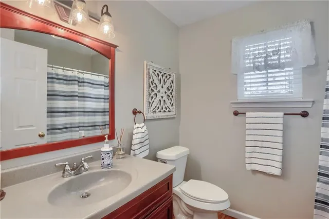 a bathroom with a sink a toilet and a window