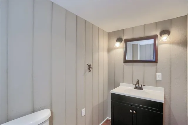a bathroom with a toilet a sink and mirror