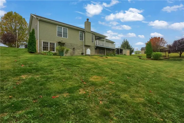 a view of a yard in front of a house with a large tree