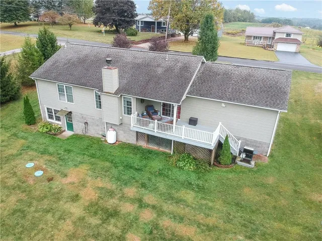 an aerial view of a house with a garden and a yard