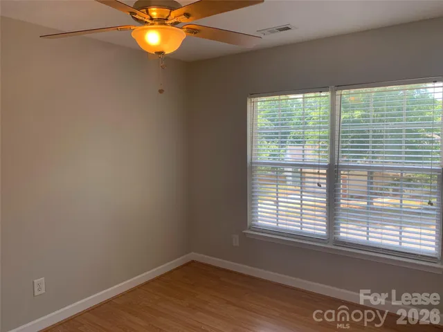 a view of a room with a window and wooden floor