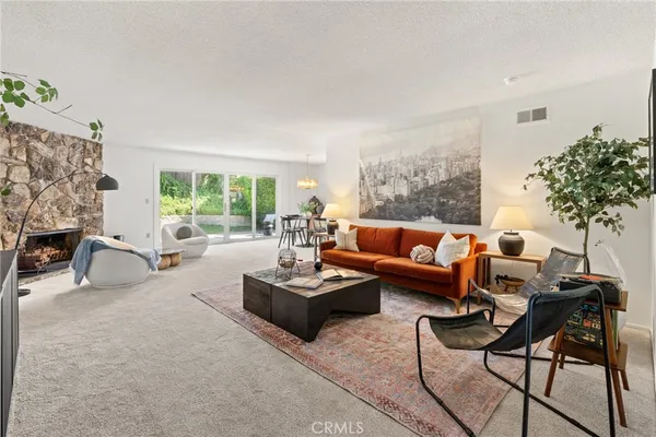 a living room with furniture a fireplace and a potted plant