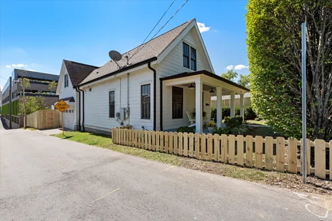 a porch with a table and chairs and potted plants