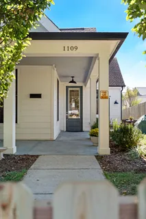a kitchen with a sink dishwasher a refrigerator and cabinets with wooden floor