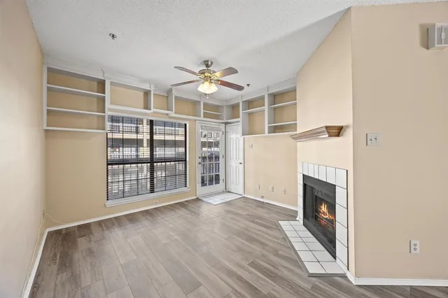 a view of an empty room with a fireplace and a window