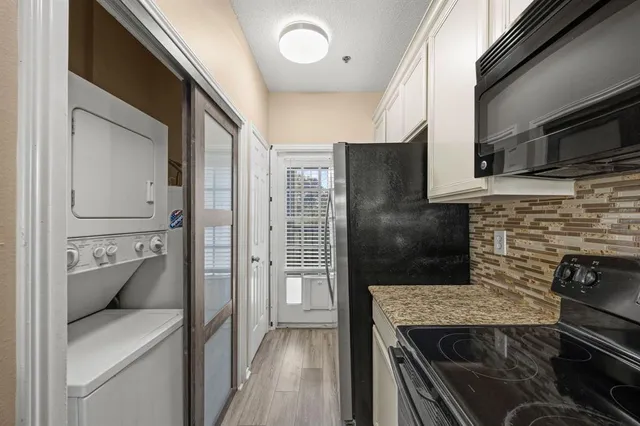 a kitchen with stainless steel appliances granite countertop a refrigerator and a stove top oven