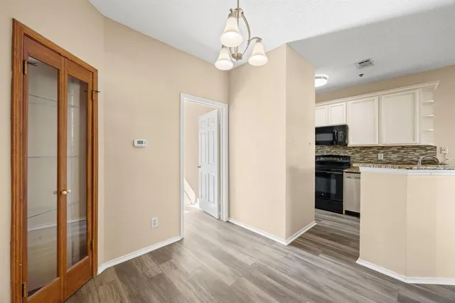 a view of kitchen with granite countertop cabinets and refrigerator