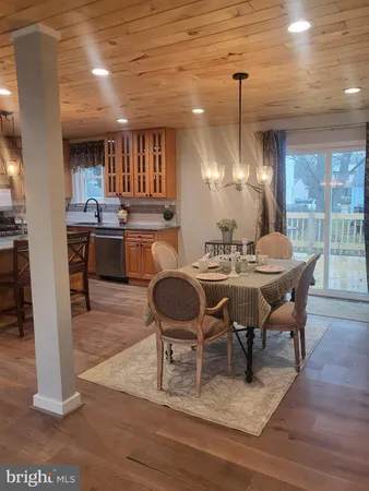 a dining room with furniture a chandelier and wooden floor