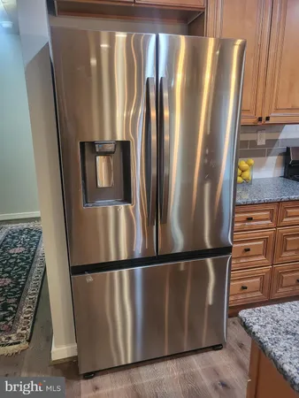 a view of a refrigerator in kitchen and wooden floor