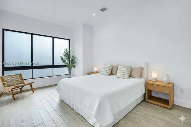 a bedroom with a bed and a large window