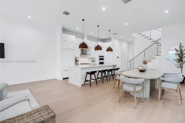 a large room with lots of white furniture and a chandelier