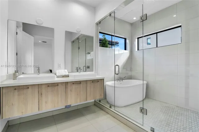 a bathroom with a sink mirror and a bathtub