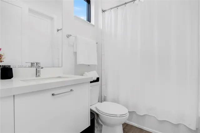 a bathroom with a sink a toilet and a mirror