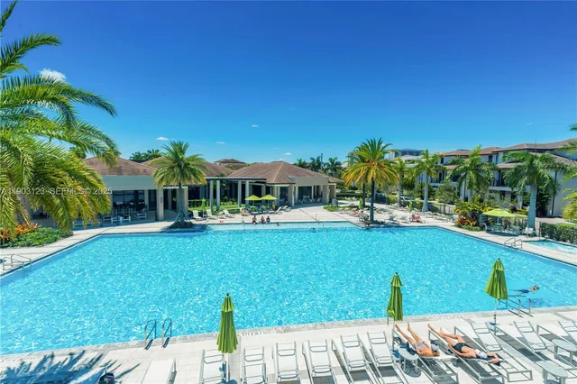 a view of swimming pool with lawn chairs and plants
