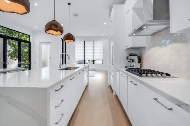 a large kitchen with stainless steel appliances lots of counter space and a sink