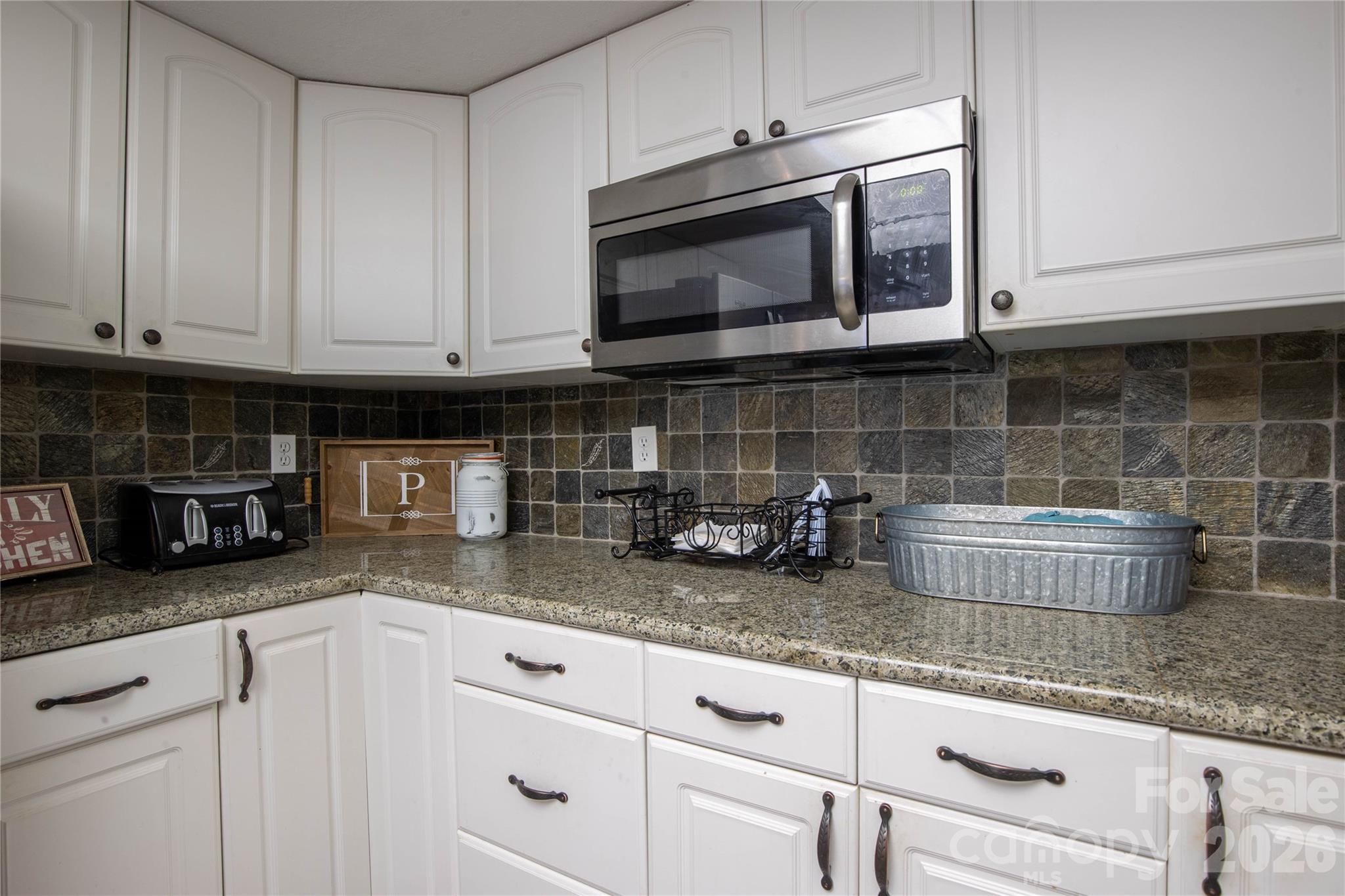84 Sheets Farm Road Bakersville, NC 28705 - Photo 15 of 42 a kitchen with granite countertop white cabinets stainless steel appliances and a counter space