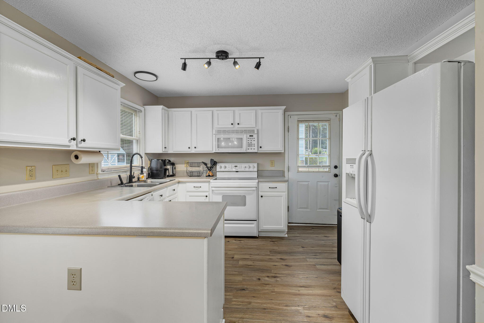 403 Chadbourne Drive Durham, NC 27703 - Photo 11 of 30 a kitchen with refrigerator cabinets and a sink