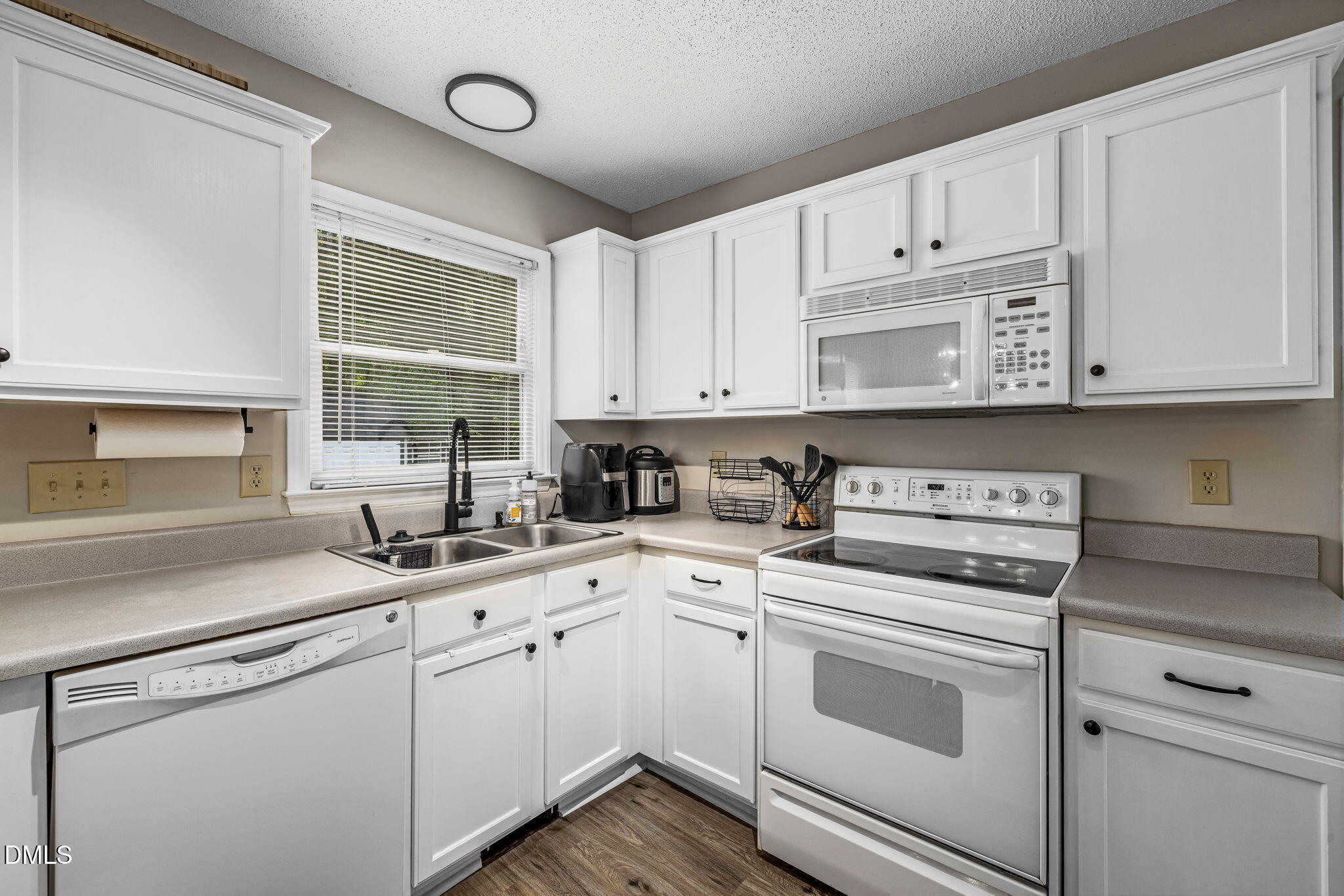 403 Chadbourne Drive Durham, NC 27703 - Photo 12 of 30 a kitchen with cabinets appliances a sink and a window