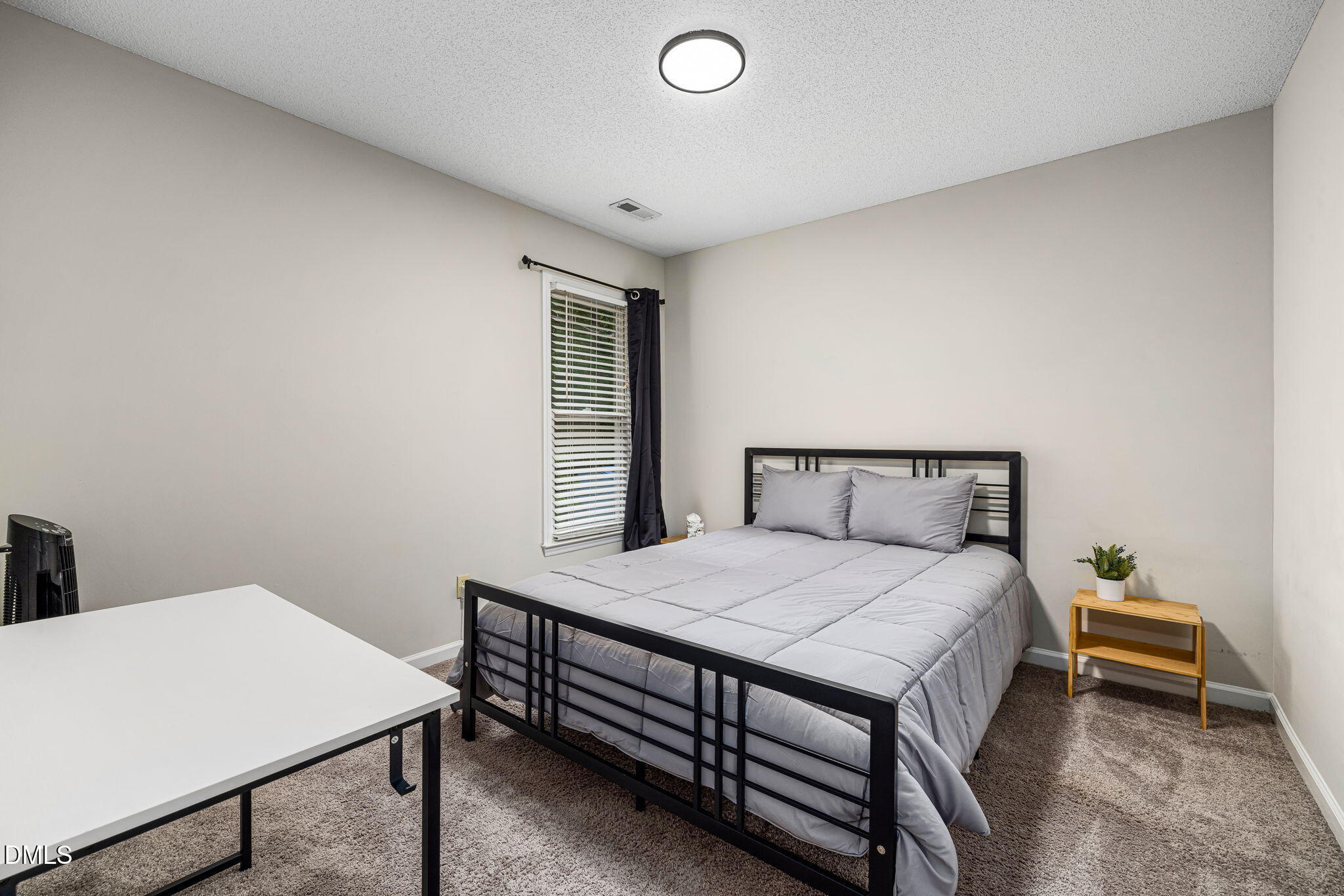 403 Chadbourne Drive Durham, NC 27703 - Photo 18 of 30 a bedroom with a bed and a table
