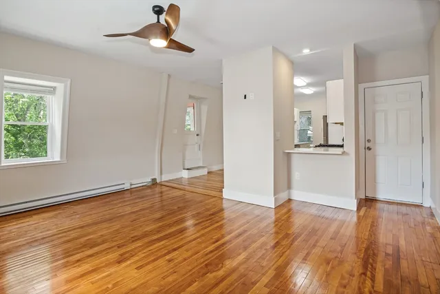a view of a kitchen with wooden floor and a ceiling fan