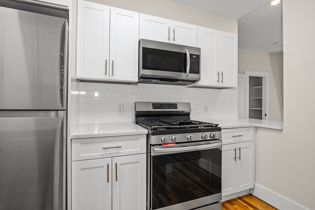 35 Oak Avenue, Unit 3 Worcester, MA 01605 - Photo 5 of 24 a kitchen with stainless steel appliances white cabinets and a stove top oven