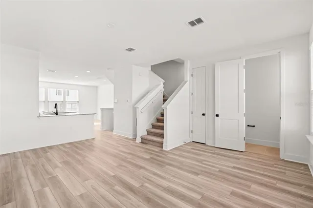 a view of a kitchen with wooden floor and stairs