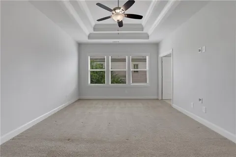 an empty room with a ceiling fan and window