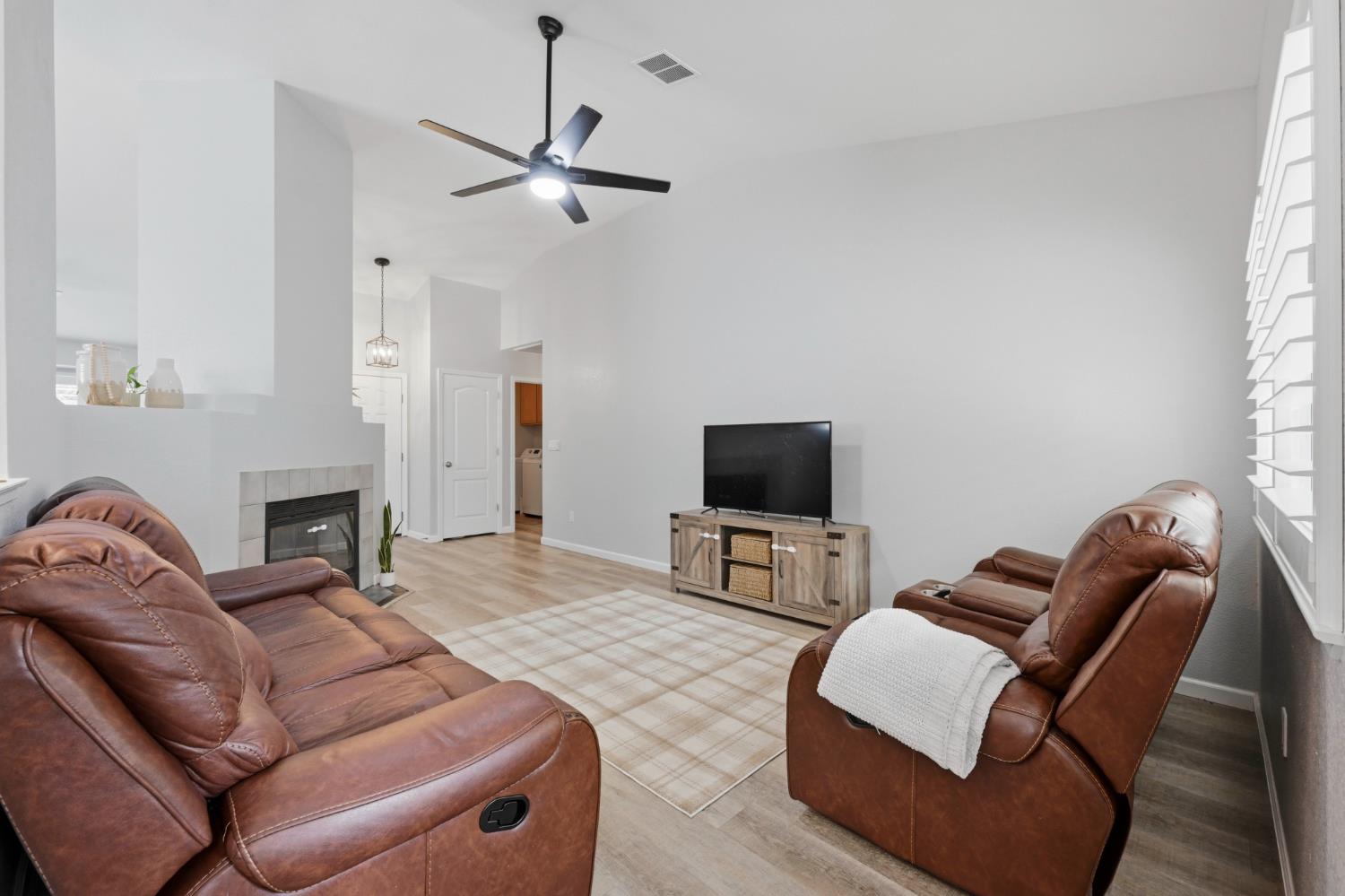 5013 Charter Road Rocklin, CA 95765 - Photo 10 of 35 a living room with furniture a fireplace and a flat screen tv