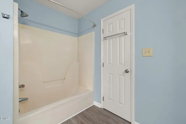 a bathroom with a tub double vanity sink and mirror