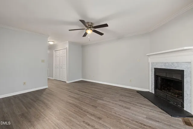 a view of empty room with wooden floor and fireplace