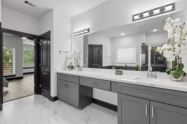 a bathroom with a double vanity sink mirror and shower