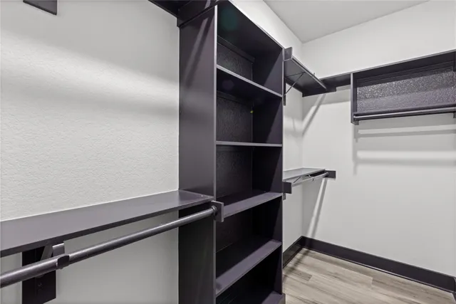 a view of walk in closet with empty racks