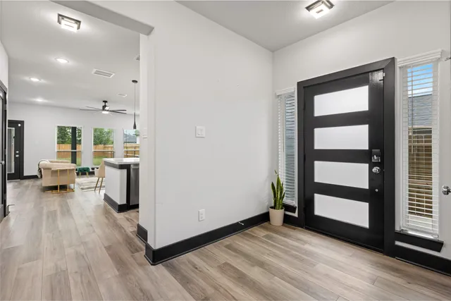 an empty room with wooden floor and entrance to ceiling window