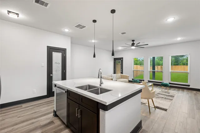 a kitchen with center island a sink appliances and wooden floor