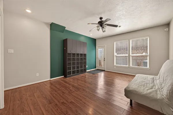 a view of an empty room with a window and wooden floor