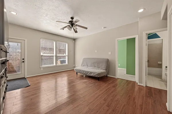 a living room with furniture and a wooden floor
