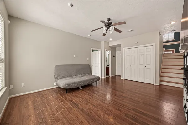 a living room with wooden floor and ceiling fan