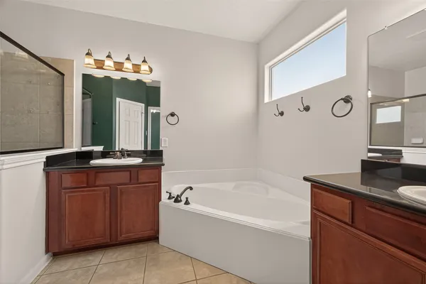 a bathroom with a tub sink and mirror
