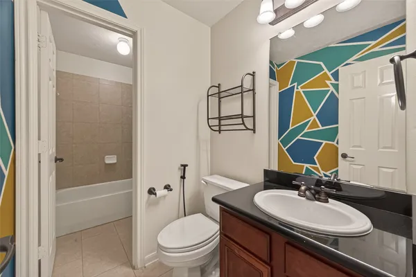 a bathroom with a granite countertop sink a toilet and shower