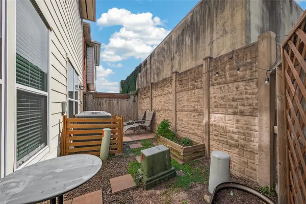 a backyard of a house with barbeque oven table and chairs