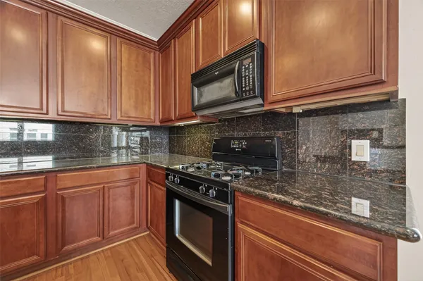 a kitchen with stainless steel appliances granite countertop a stove microwave and cabinets
